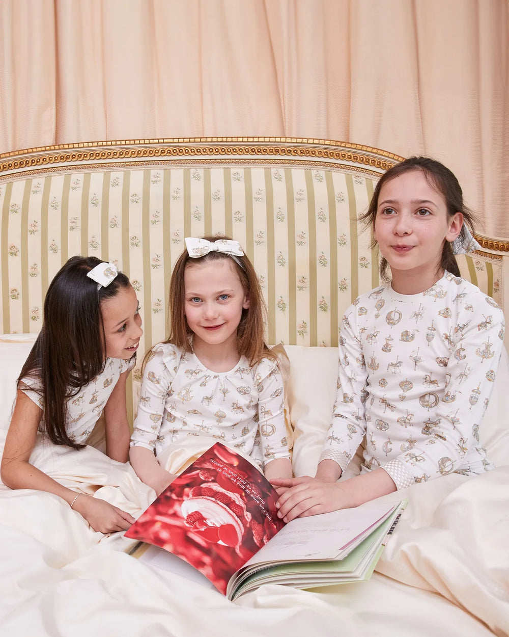 Meisje met Atelier Choux Carousel haarband en Carousel pyjama in luxe Franse slaapkamer