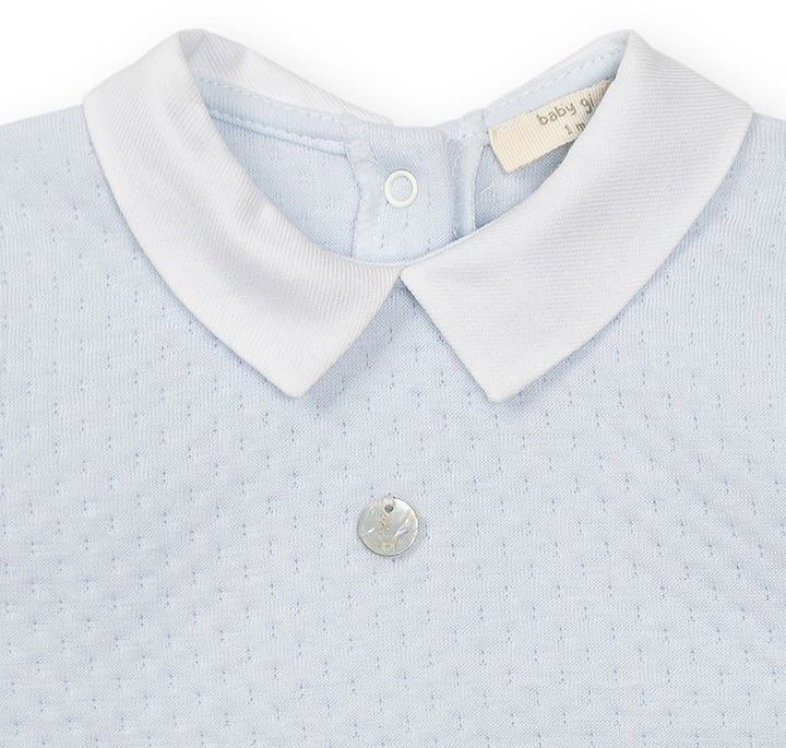 Baby Gi lichtblauw boxpakje met klassieke kraag, ajourpatroon en voetjes voor baby's. detail van punt kraagje en patroon