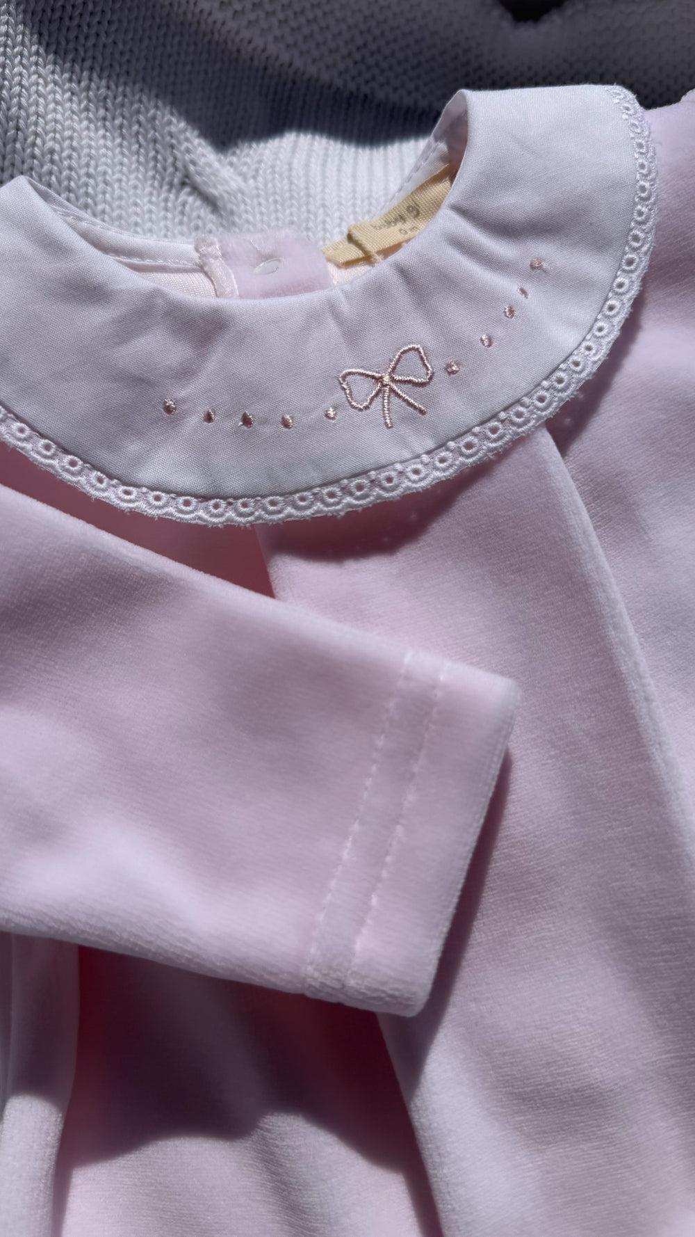 Lichtroze velours babypakje met witte kraag met geborduurde strik van het merk baby gi 