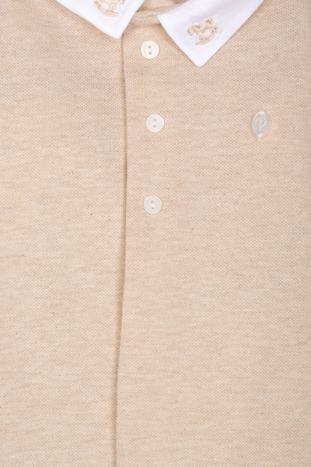 Detail van geborduurde hobbelpaardjes op de kraag van Patachou babypakje 