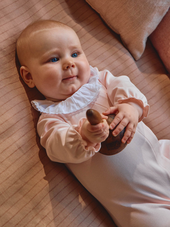 Peach Pink babypakje van Laranjinha aan baby