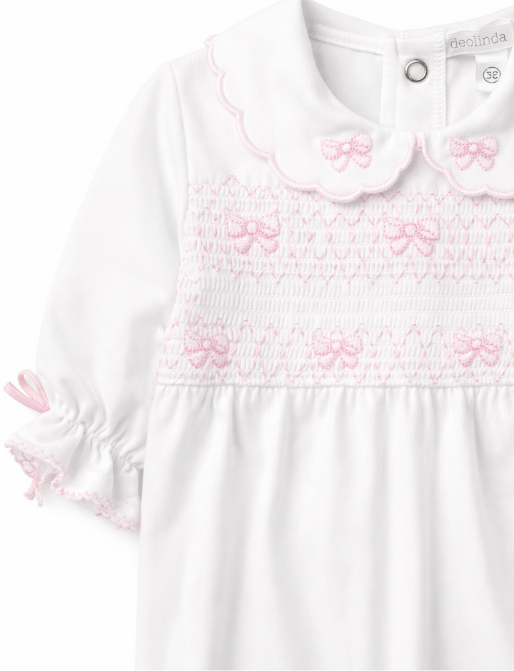 Detail van meisjes babypakje met strikjes en smockwerk van Deolinda