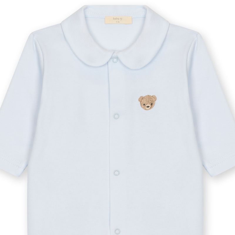 Detail van lichtblauw babypakje met ronde kraag en geborduurd beertje Baby Gi 