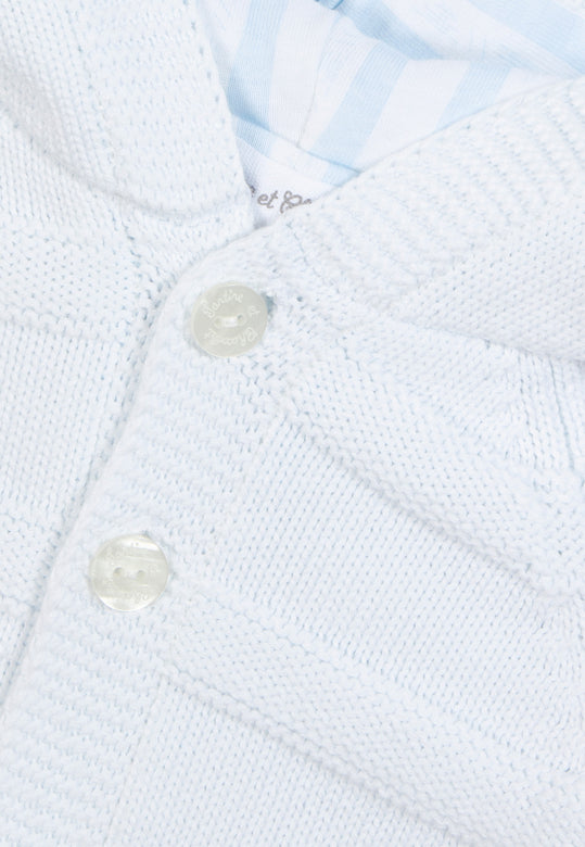 Detail van het verfijnde breisel van het gebreide lichtblauwe babyjasje van Tartine et Chocolat