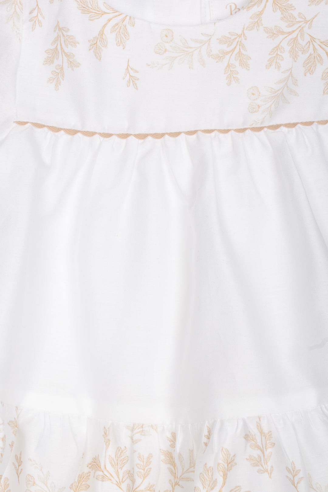 Detail van wit baby jurkje met fijne leaf print