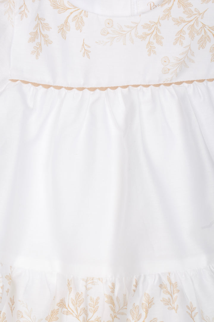 Detail van wit baby jurkje met fijne leaf print