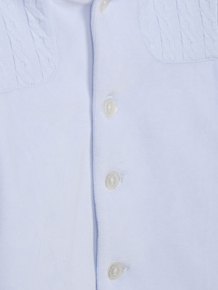 Detail van velours babyjasje in lichtblauw 