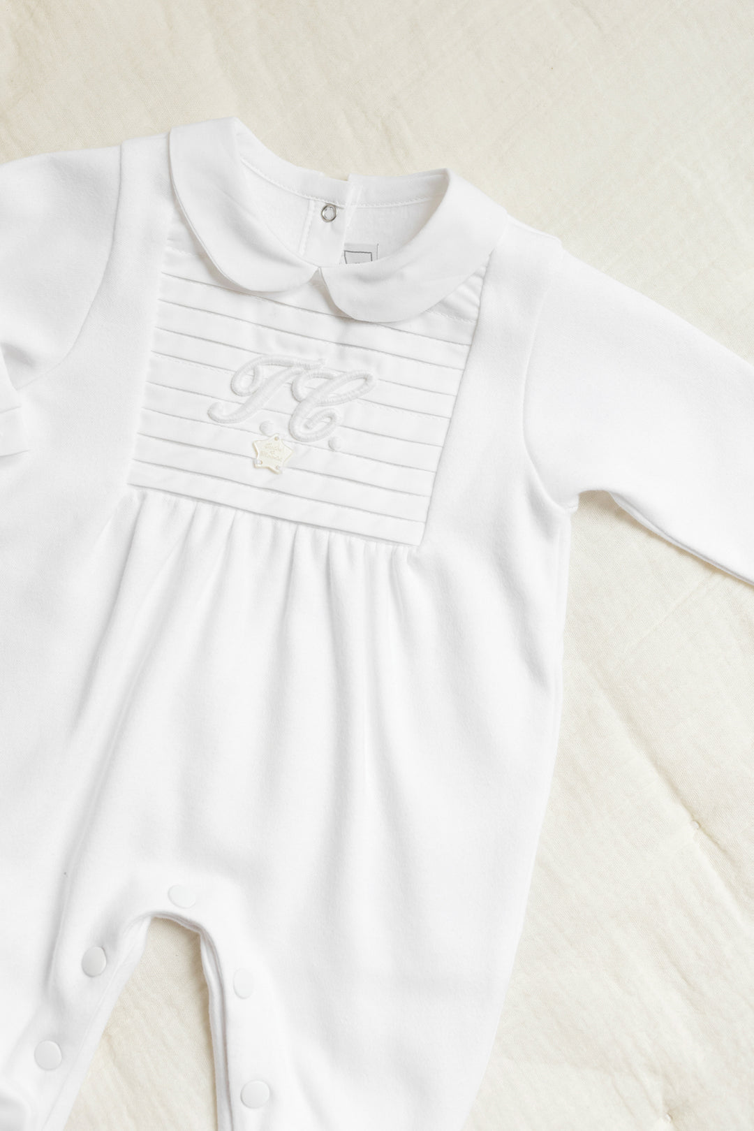 unisex babypakje in offwhite met plisse details en TC logo met ronde kraag van Tartine et chocolat 