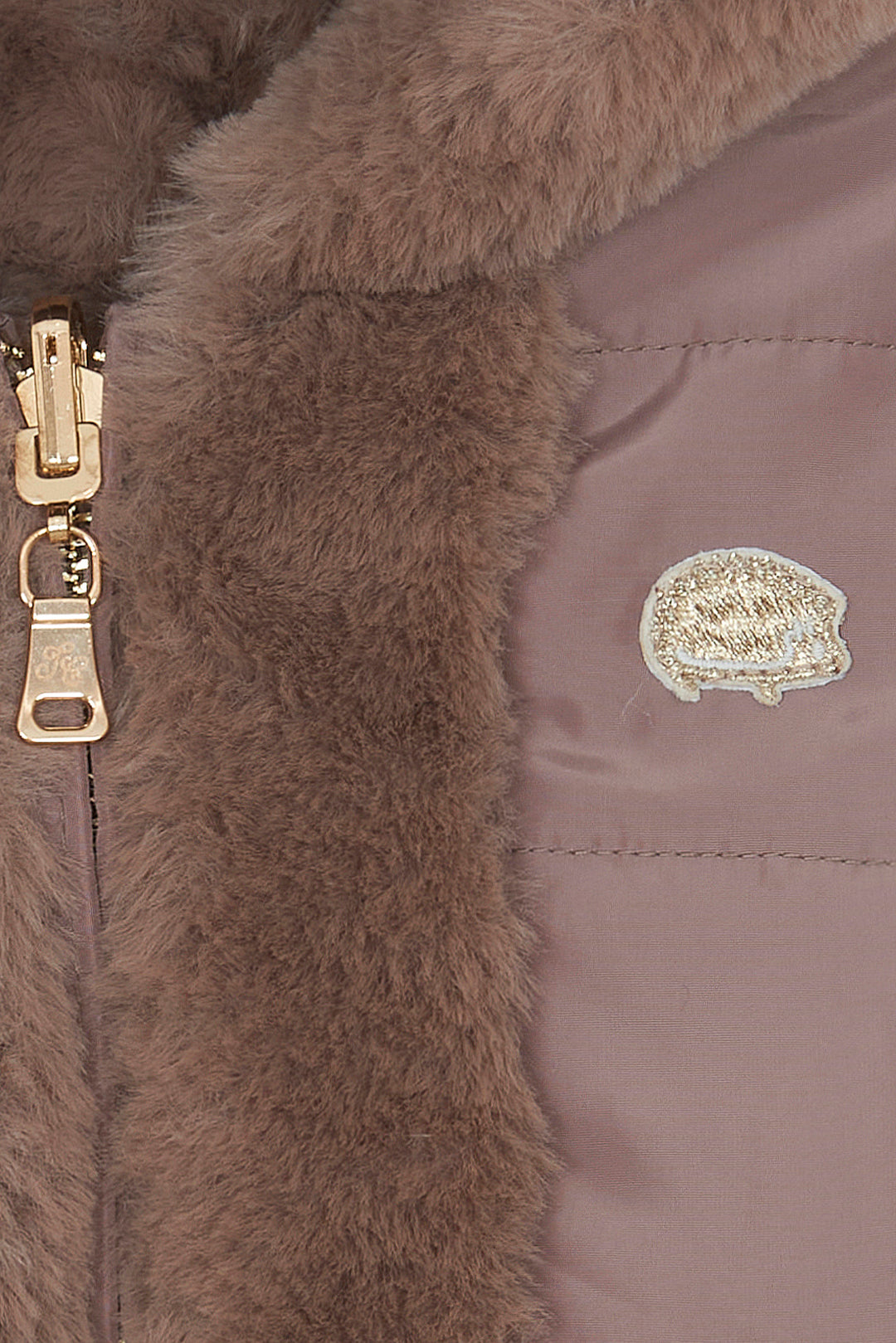 detail van winterjas met bontvoering en egel embleem in goud van tartine et chocolat